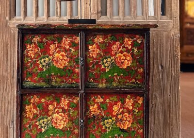 Antique tibetan small cabinet with red background and colourful flowers