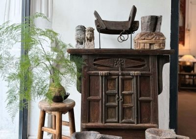 Chinese antique furniture, Shanxi coffer cabinet, stools, rustic wooden bowls against a white wall