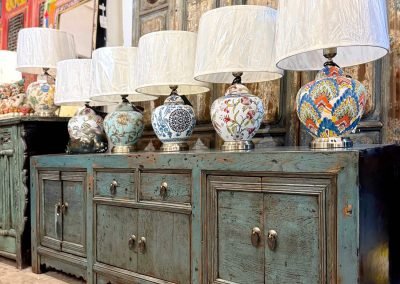 A vintage low blue Gansu sideboard with a row of colourful ceramic table lamps