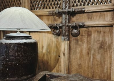 Chinese antique furniture, antique chinese door panels in natural wood colour and cast iron handles, a large old pot table lamp